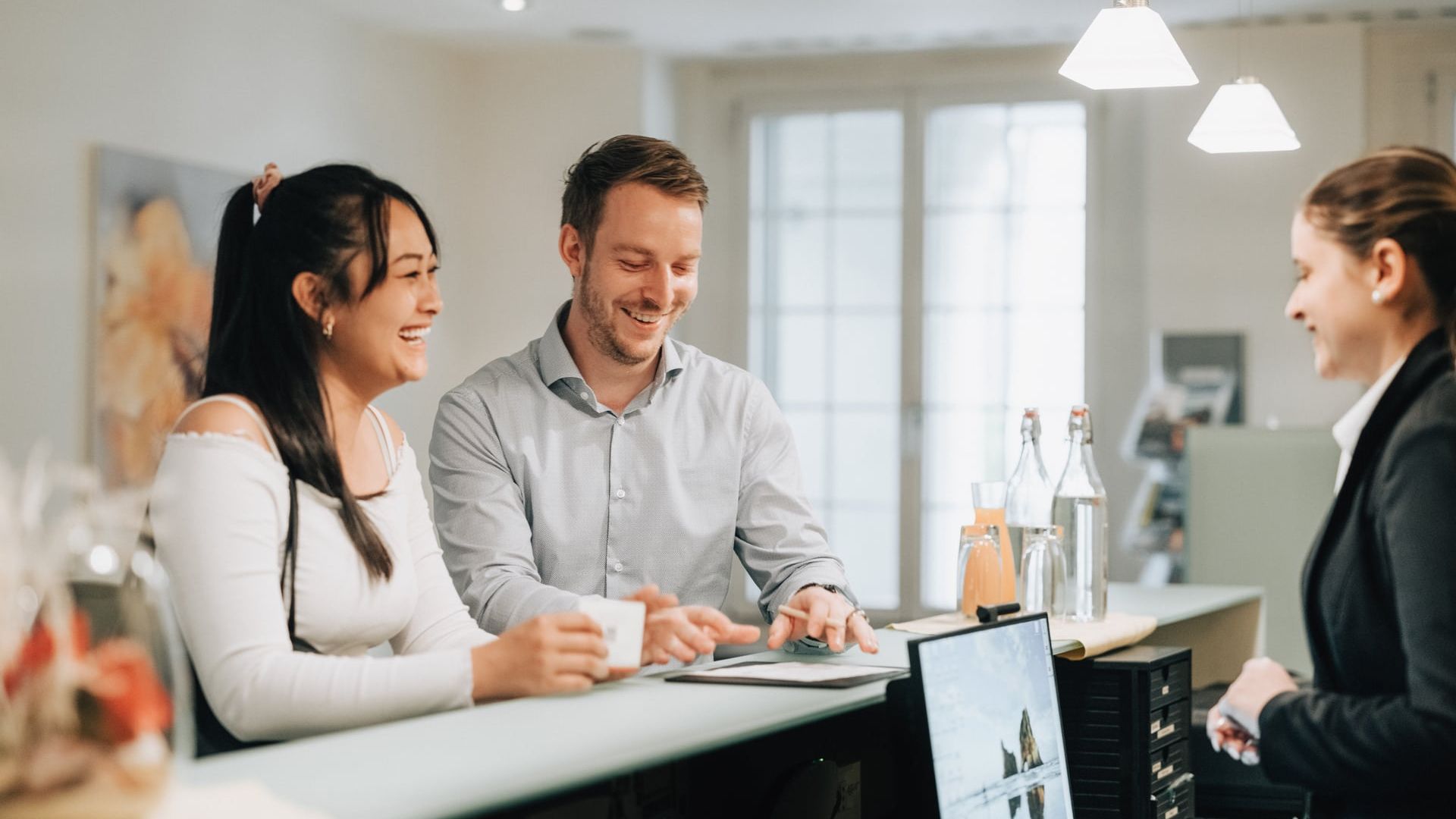 Business-Gäste beim Check-in an einer Hotelrezeption im Thunersee-Meeting-Setting