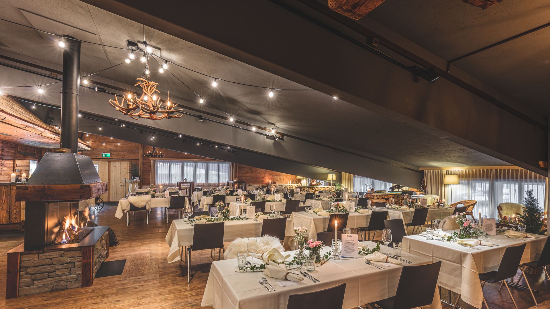 Stilvoller Seminar- und Eventraum mit gedeckten Tischen und Kamin im Berner Oberland