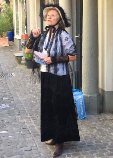 Historisch kost&uuml;mierte Frau mit Hut auf Kopfsteinpflaster in Thun