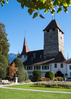Sunny exterior view of Spiez Castle on Lake Thun with its well-tended garden, lawns and view of the Alps. Ideal as an inspiring backdrop for meetings, corporate events and aperitifs in the Lake Thun region in the canton of Bern – central, quiet and prestigious. ©Spiez Castle Spiez Castle on Lake Thun