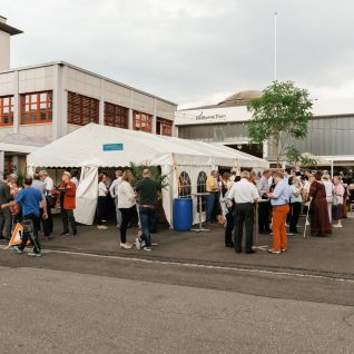Networking-Apéro im Eventzelt vor Industriegebäude in Thun