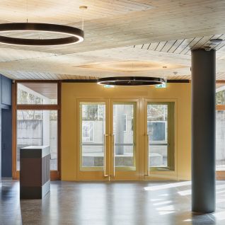 Modernes Foyer mit Holdecke, Ring-Leuchten und Glastüren in Thun