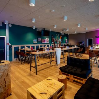 Moderner Eventraum mit Hochtischen, Lounge und Bar im Thun-Thunersee MICE-Setup