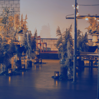 A stylish event venue with candlelight and dried flower decorations in the warm evening light