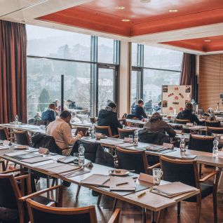 Seminarraum mit Teilnehmenden und Panoramafenstern mit Blick auf die Berge