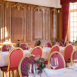 Eleganter Bankettsaal mit gedeckten Tischen und roten Stühlen
