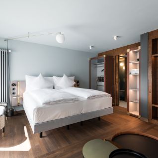 Modernes Doppelzimmer mit Boxspringbett und Holzdetails im Thunersee-Hotel