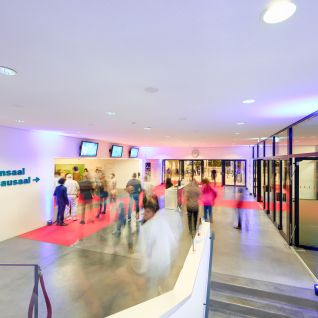 Besuchergruppe im beleuchteten Foyer am Eingang zum Lachensaal Schadau