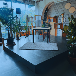 Kreativer Meetingraum mit Pflanzen, Bühne und grosser Fensterfront