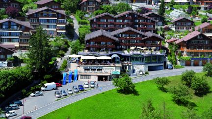 Luftaufnahme eines modernen Veranstaltungsortes inmitten traditioneller Schweizer Chalets oberhalb des Thunersees. Die großzügige Terrasse und der Blick ins Grüne bieten ideale Bedingungen für Business-Events und Tagungen in inspirierender Alpenkulisse. Perfekt für Meetings kleiner und mittlerer Unternehmen. ©Solbad Vogelperspektive auf Veranstaltungsort am Thunersee
