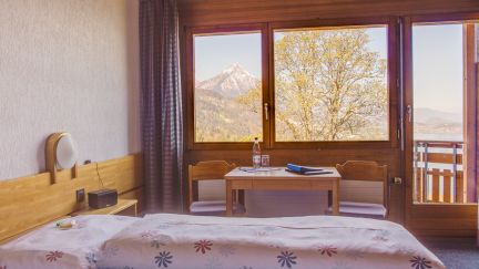 Bright, quiet guest room with double bed, wooden accents and large window overlooking Lake Thun and the mountains. In front of the window is a table for conversations or concentrated work – ideal as accommodation for seminars, workshops and business events in the Lake Thun region. ©Meielisalp Seminar room with lake view