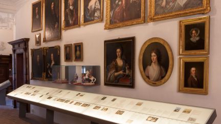 Historischer Museumsraum mit Portr&auml;tgalerie und Vitrinentisch in Thun