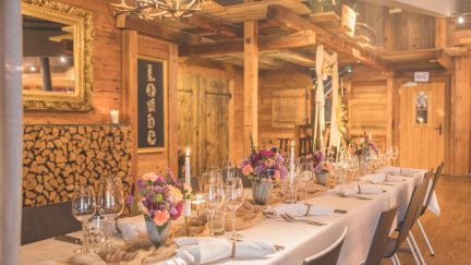 A long table festively laid in a rustic chalet for a business event on Lake Thun