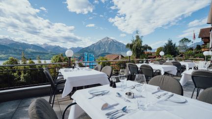 Elegantly laid tables on a sunny terrace with stunning views of Lake Thun and the surrounding Alps. Perfect for business events, corporate dinners or meetings in an exclusive setting against the inspiring natural backdrop of the Lake Thun region in the canton of Bern. ©Solbad Elegant al fresco dining with views of the Alps