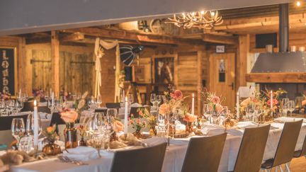 Festlich gedeckte lange Tafel in rustikaler Eventscheune am Thunersee