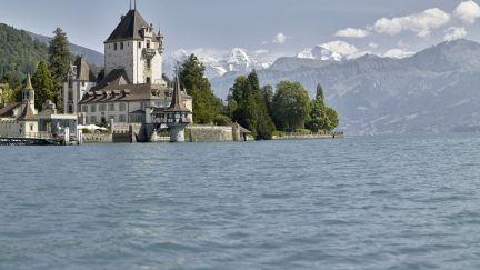 Blick vom Wasser auf Schloss Oberhofen am Thunersee, umgeben von Bäumen und Bergen – inspirierende Kulisse für Meetings und Events im Berner Oberland. ©Schloss Oberhofen Schloss Oberhofen am Thunersee mit Alpenpanorama