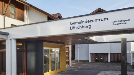 Eingang Gemeindzentrum L&ouml;tschberg mit &Uuml;berdachung und Vorplatz