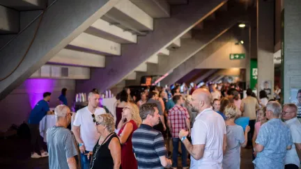 Networking event in the foyer with guests gathered under the stairs
