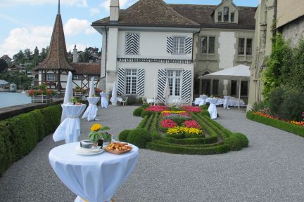 Ap&eacute;ro-Empfang im Schlosshof am Thunersee mit Stehtischen und Blumenbeeten