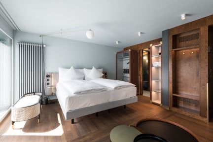 Modernes Doppelzimmer mit Boxspringbett und Holzdetails im Thunersee-Hotel