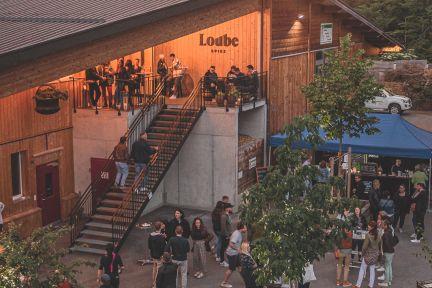 Gäste treffen sich vor der Eventlocation Laube mit Terrasse und Treppe – stimmungsvolle Abendatmosphäre für Firmenanlässe in der Thunersee-Region. ©Loube Spiez Abendlicher Apéro und Networking auf der Terrasse der Laube bei Sonnenuntergang