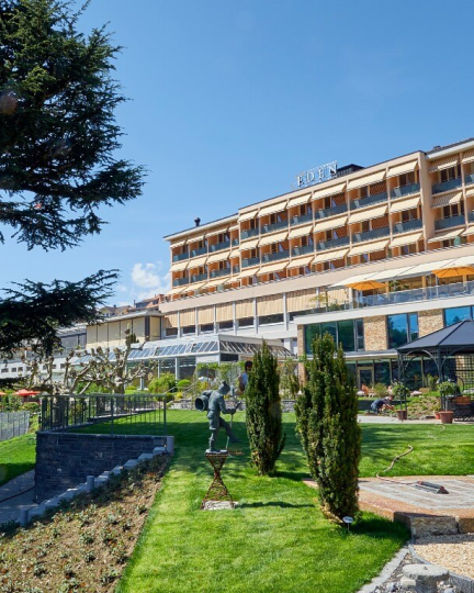 Grosses Hotel am Seeufer mit gepflegtem Garten, Wegen und Terrasse – ideal für Meetings und Firmenanlässe in der Region Thun-Thunersee. ©Eden Spiez Hotel am Thunersee mit Gartenanlage und Terrasse bei Sonnenschein