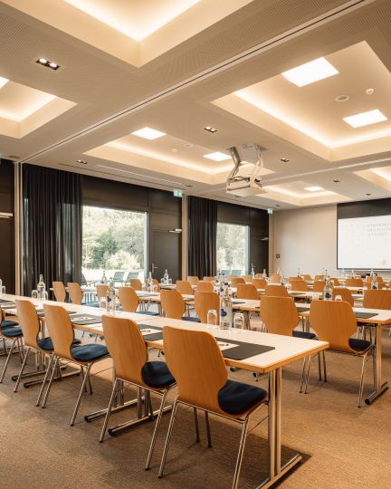 Heller, großzügiger Seminarraum mit flexibler Bestuhlung, großen Fenstern und moderner Präsentationstechnik. Die stilvolle Einrichtung sorgt für eine produktive Atmosphäre und bietet ideale Bedingungen für Workshops, Tagungen oder Meetings am Thunersee. ©Deltapark Moderner Seminarraum in Thun