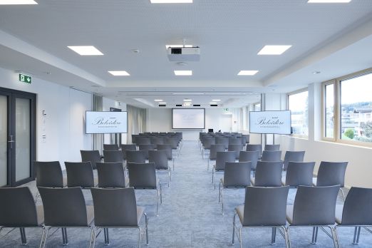 Moderner Tagungsraum mit Reihenbestuhlung, Präsentationsleinwand und Tageslicht – ideal für Workshops, Seminare und Business-Events in der Region Thun. ©Strandhotel Belvédère Heller Seminarraum mit Reihenbestuhlung und Leinwand für Meetings am Thunersee