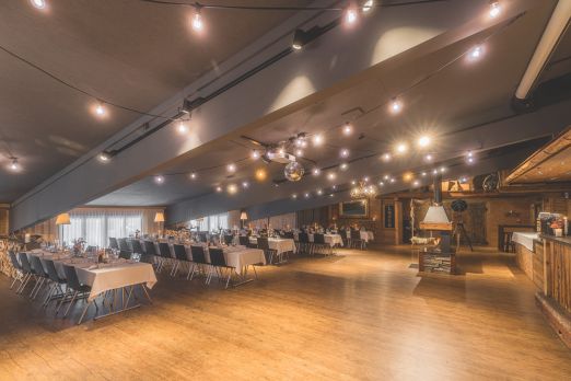 Grossz&uuml;giger Bankettsaal mit gedeckten Tischen und Holzbar f&uuml;r Events am Thunersee