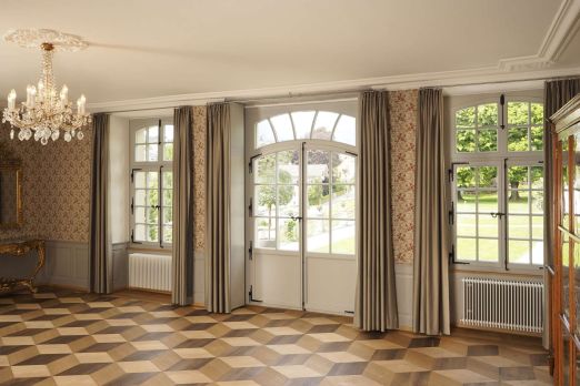 Eleganter Eventraum mit Parkettboden, Kronleuchter und bodentiefen Fenstern