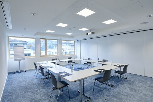 Heller Seminarraum mit U-Tischbestuhlung und moderner Pr&auml;sentationstechnik