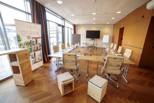 Moderner Meetingraum mit großen Fenstern, U-Form-Tischen, Whiteboard und Flipchart – ideal für Workshops und Tagungen am Thunersee. ©Eden Spiez Heller Seminarraum mit U-Form-Bestuhlung und Seeblick in der Region Thun-Thunersee
