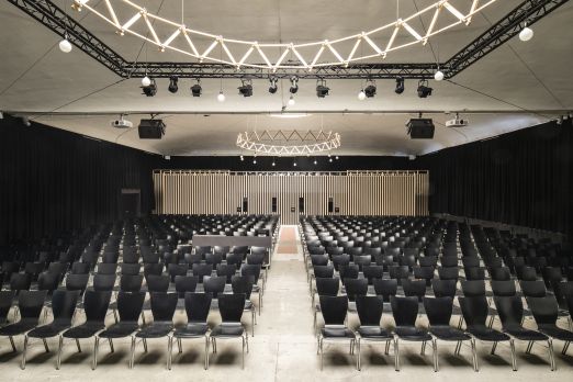 Geräumiger, lichtdurchfluteter Saal mit moderner Ausstattung und zahlreichen Sitzplätzen, ideal für Konferenzen, Tagungen und Business-Events. Die stilvolle Beleuchtung und flexible Bestuhlung bieten einen professionellen Rahmen für Veranstaltungen am Thunersee in der Region Bern. ©Westhalle Thun Modernes Konferenzzentrum am Thunersee