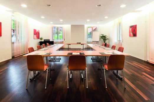 Heller Seminarraum mit U-Bestuhlung, Parkettboden und Tageslicht