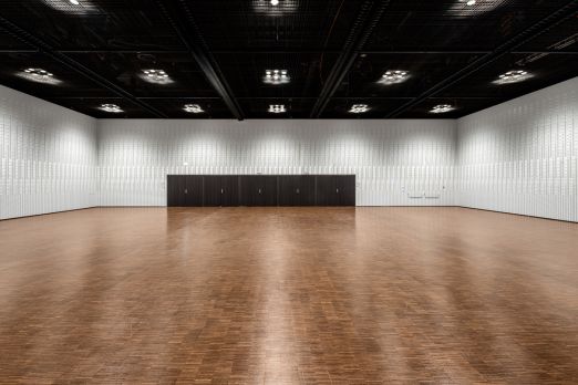 Weitläufiger, heller Saal mit Holzparkett, weissen Wänden und kleiner Bühne – flexibel für Meetings, Kongresse und Firmen-Events am Thunersee. ©KKThun Grosse, moderne Eventhalle mit Holzparkett und Bühne