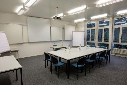 Heller Seminarraum mit U-Form Bestuhlung, Beamer und Flipchart