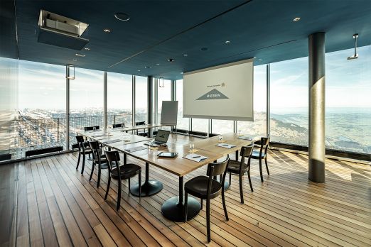Heller Meetingraum mit Bildschirm, Board und Bestuhlung auf Holzdeck – ideal für Workshops und Konferenzen mit Weitblick in der Schweiz. ©Niesen Moderner Seminarraum mit Panoramablick über Thun-Thunersee Region
