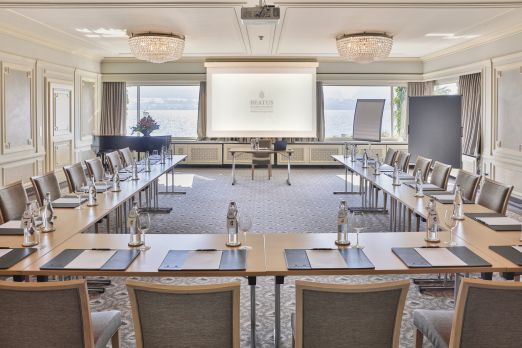 Heller Konferenzraum mit U-Bestuhlung, Leinwand und Seeblick am Thunersee