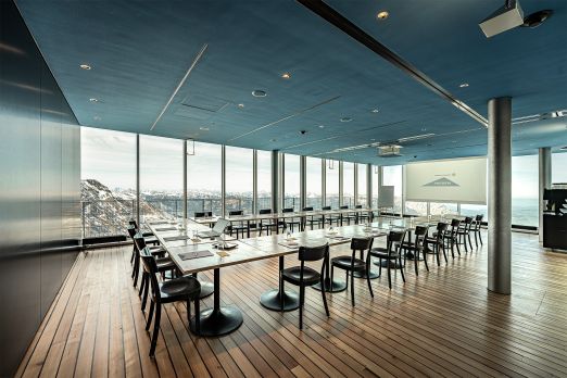Heller Event- und Tagungsraum mit Holzboden, langen Tischen und Seesicht – ideal für Meetings und Workshops in der Region Thun-Thunersee. ©Niesen Moderner Seminarraum mit Panoramafenstern und Blick auf den Thunersee