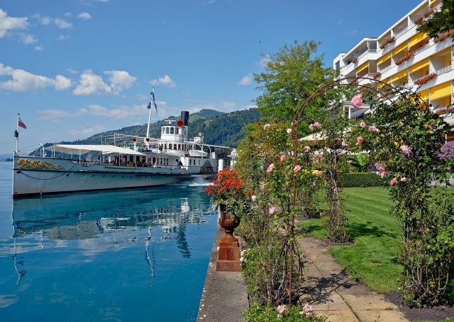 Passagierschiff am Thunersee vor Uferpromenade mit Blumen und Hotelbalkonen