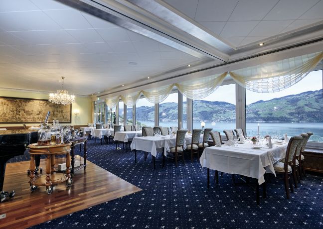 Heller Eventraum mit gedeckten Tischen, Teppichboden und Panoramafenstern – ideal für Business-Dinners und Meetings mit Blick auf den Thunersee. ©Belvédère Strandhotel Eleganter Bankettsaal mit Seeblick am Thunersee