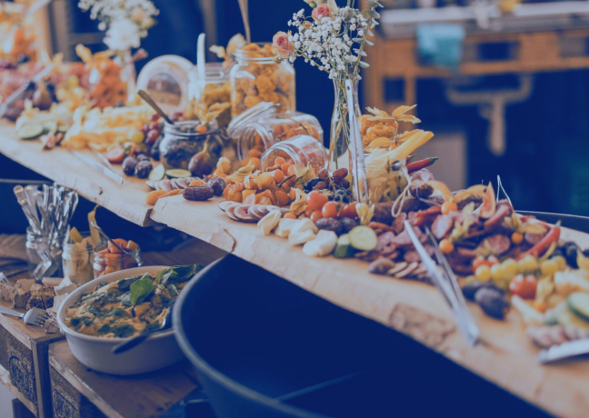 Liebevoll angerichtetes Catering mit Käse, Früchten und Snacks – ideal für Business-Events in der Region Thun-Thunersee.
©Frachtraum Thun Apéro-Riche-Buffet auf Holzbrett mit Fingerfood und Blumen dekoriert