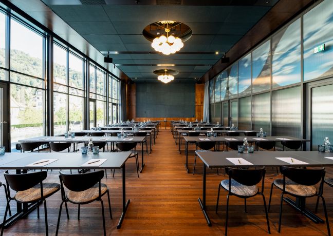 Heller Konferenzraum in Reihenbestuhlung mit Holzboden, moderner Beleuchtung und Blick ins Grüne – ideal für Meetings und Workshops in der Region Thun. ©Hotel Aare Moderner Seminarraum mit Tischreihen und Panoramafenstern am Thunersee