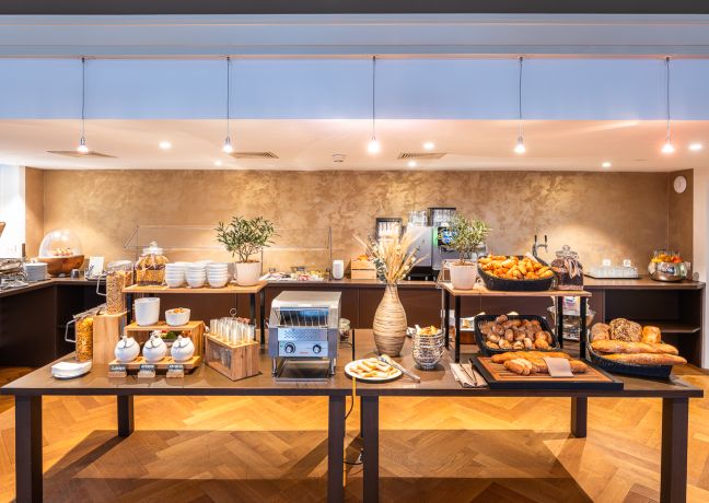 Fr&uuml;hst&uuml;cksbuffet in modernem Hotelrestaurant mit Brot, Geb&auml;ck und Kaffestation