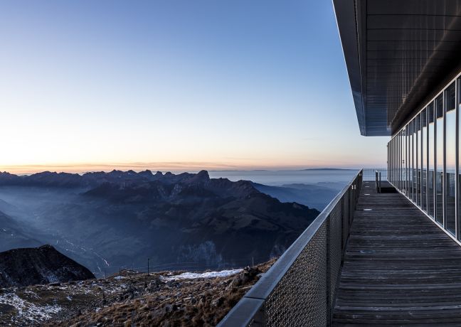 Panoramaterrasse mit Glasfassade und Blick auf die Berner Alpen bei Sonnenaufgang