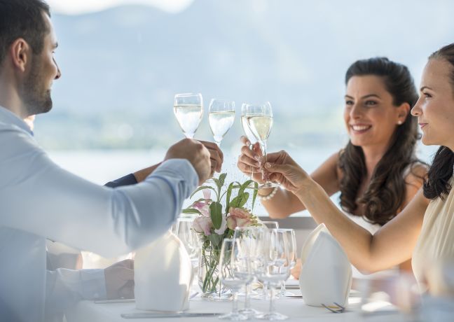 Business-G&auml;ste stossen beim Dinner am Thunersee mit Blick auf die Alpen an