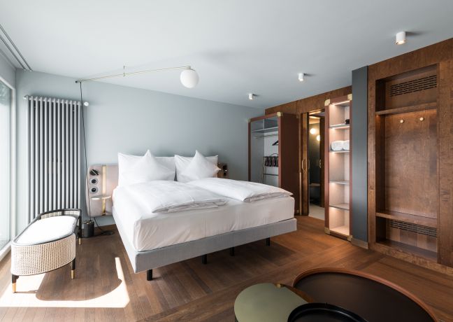 Modernes Doppelzimmer mit Boxspringbett und Holzdetails im Thunersee-Hotel
