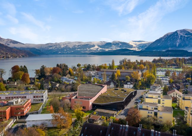 Das Konferenzzentrum Thun liegt eingebettet inmitten farbenfroher Gebäuden und grüner Umgebung direkt am Ufer des Thunersees. Im Hintergrund erheben sich majestätisch die Berner Alpen – ideal für inspirierende Firmenanlässe und Tagungen mit eindrucksvollem Panorama. ©KKThun Kongresszentrum Thun mit Seeblick