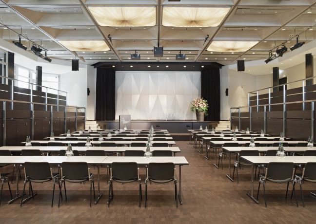 Heller, flexibel bestuhlter Konferenzsaal mit Bühne im Seepark Genève, ideal für Firmenveranstaltungen, Tagungen und Seminare. Die moderne technische Ausstattung, klare Linien und großzügige Fenster schaffen eine professionelle Atmosphäre für erfolgreiche Business-Events am Thunersee. Moderner Konferenzraum Seepark Genève