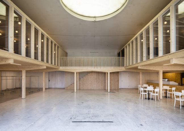 Minimalistische, lichtdurchflutete Halle mit umlaufender Galerie, grossem Oberlicht und Bestuhlung – ideal für Meetings, Apéros und Corporate Events. ©Westhalle Thun Helle Eventhalle mit Galerie und Oberlicht in Thun-Thunersee